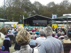 Menschen sitzen vor Veranstaltungsbühne in Domburg
