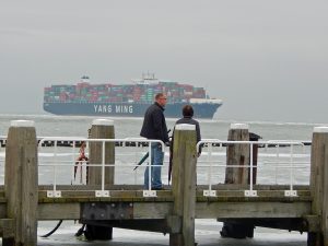 Besucher auf Stegen der Kazematten mit Containerschiff im Hintergrund