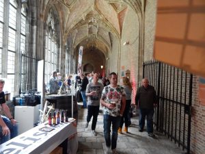 Männer mit Biergläsern gehen durch die Klostergänge der Abtei Middelburg