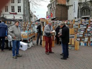 Marktverkäufer mit Kunden auf Büchermarkt in Middelburg