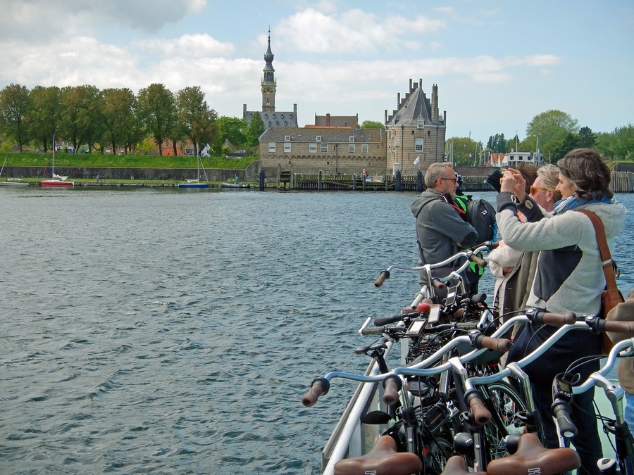 Passagiere auf Fahrradfähre vor der Kulisse vn Veere auf dem Veerse Meer