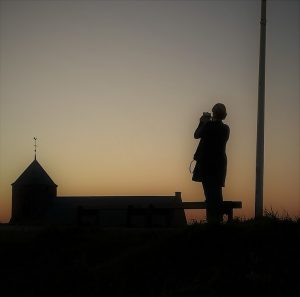 Frau mit Kirche Zoutelande in Abenddämmerung
